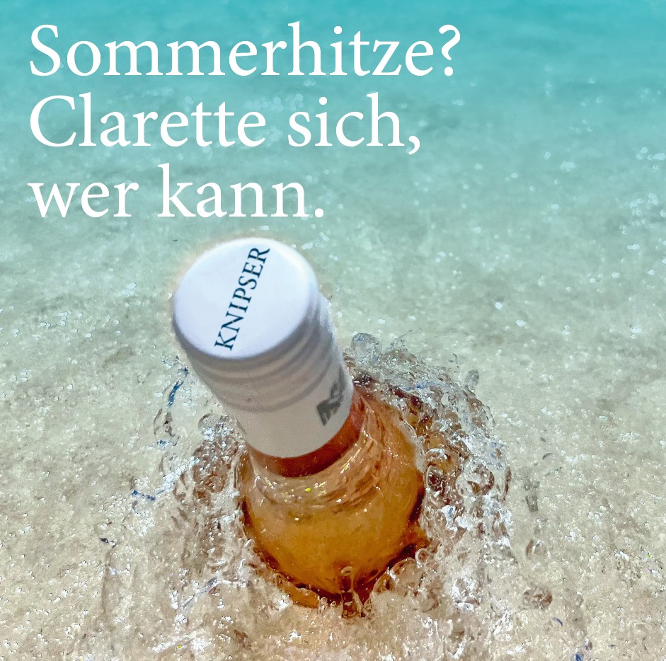 Flasche eines Rosé-Weines, welche im Meer steht und von den Wellen umspült wird. Spruch: "Sommerhitze? Clarette sich, wer kann."